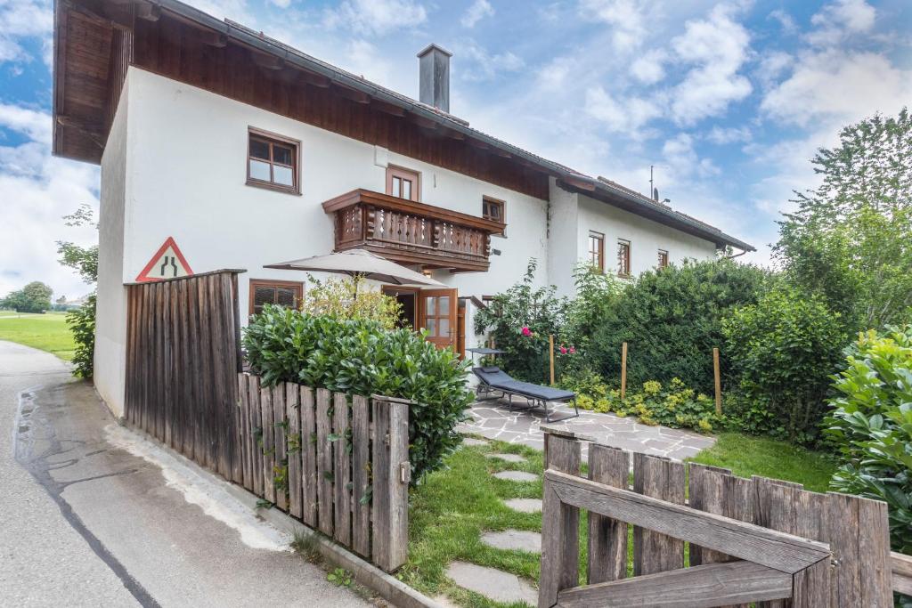a white house with a wooden fence at Zuhaus am See in Gstadt am Chiemsee