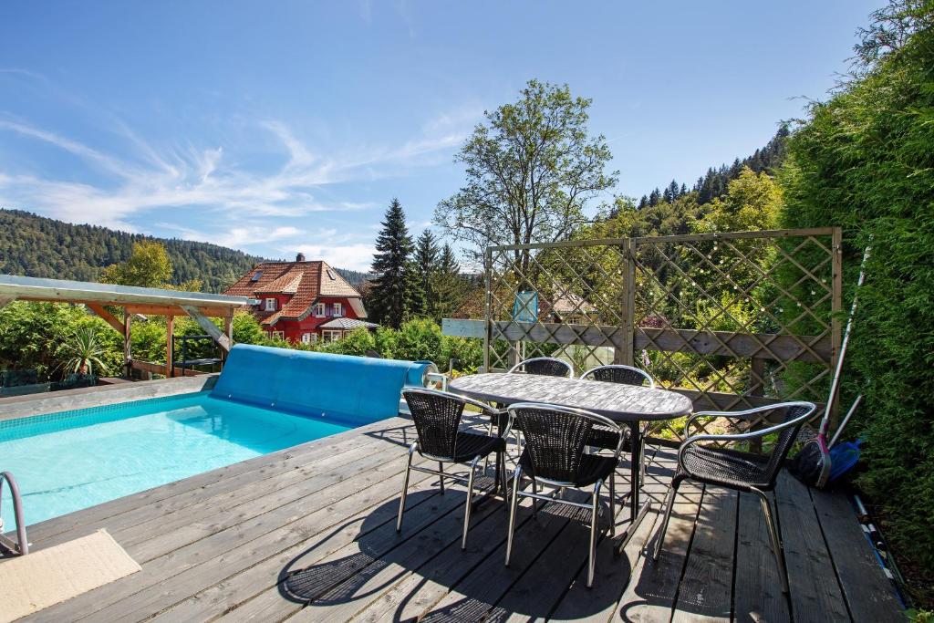 a patio with a table and chairs next to a pool at Villa Sonnenwinkel in Todtmoos