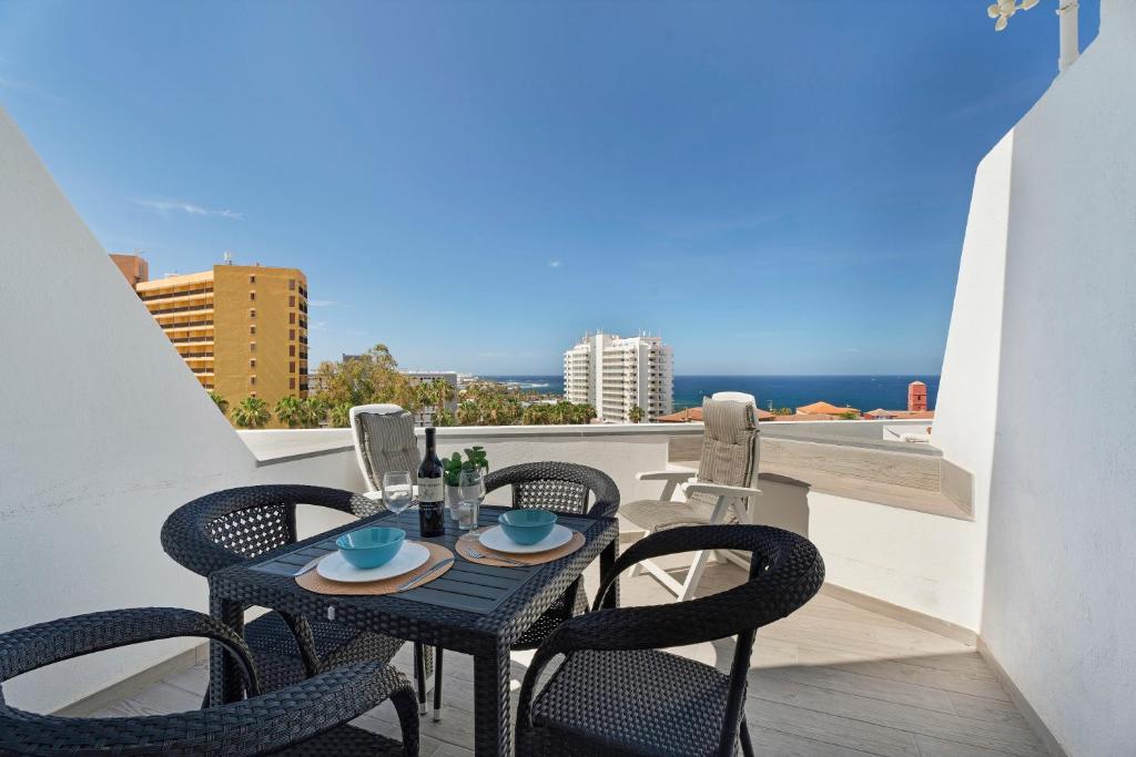 a table and chairs on a balcony with a view at Las Flores 407 in Playa Fañabe
