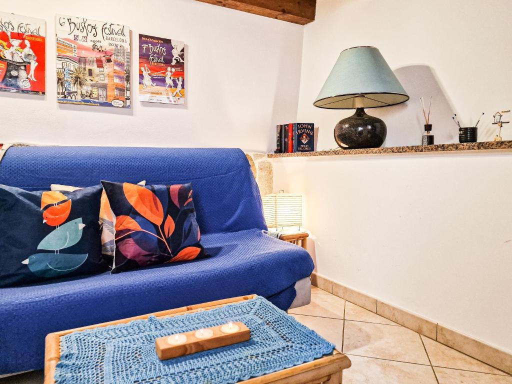 a living room with a blue couch and a table at Il Borgo 4 in Capoliveri