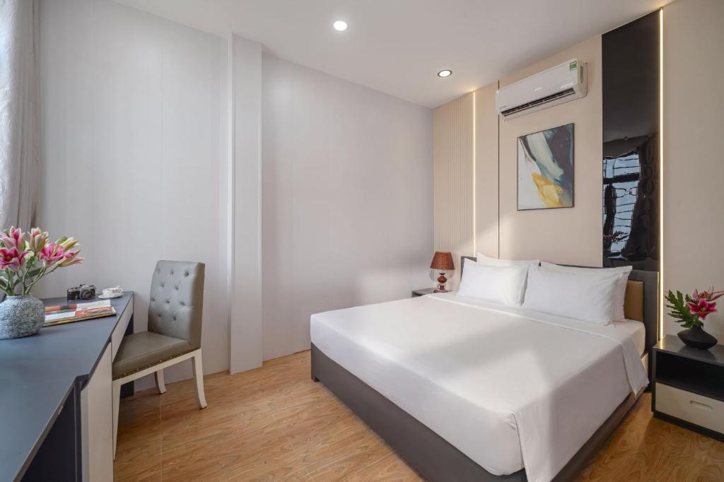 a bedroom with a large white bed and a desk at Hanami Residence - Self Check-in Accommodation in Danang
