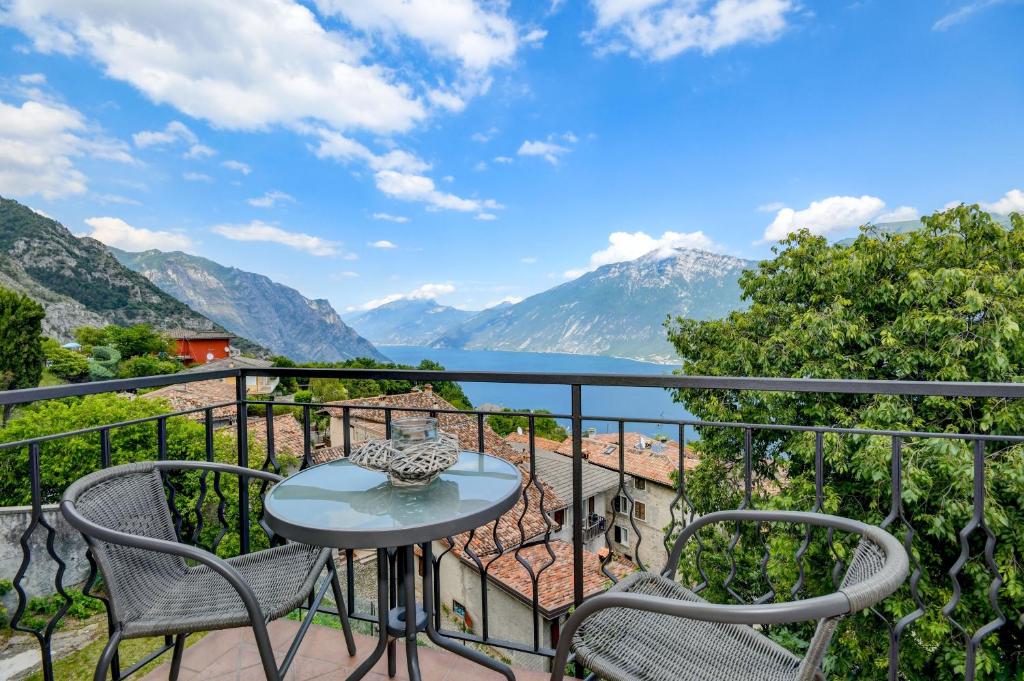 a balcony with a table and chairs and mountains at Casa Doss in Tremosine Sul Garda