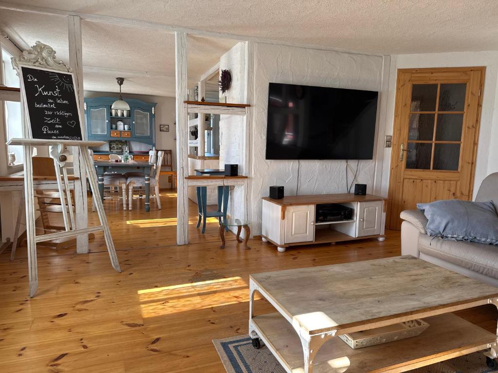 a living room with a couch and a tv and a table at Thüringer Landidyll in Bösleben-Wüllersleben