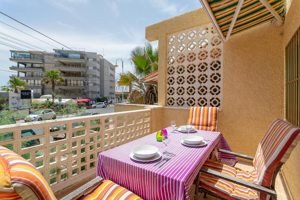 a table with plates and bowls on a balcony at Casa La Roqueta in Guardamar del Segura