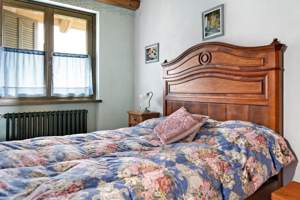 a bedroom with a large bed with a wooden headboard at Casa Vacanze il Ginepro in Sinio