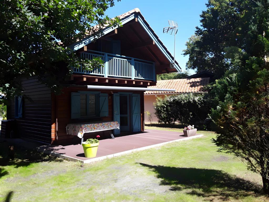 a house with a bench and a balcony at Maison de vacances Proche Arcachon in La Teste-de-Buch