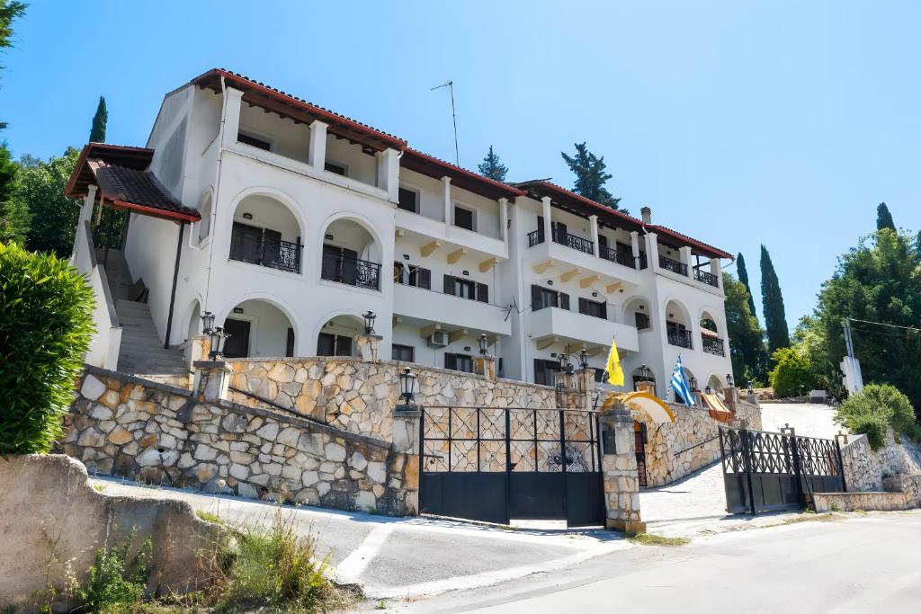 a large white building with a stone fence at Breathing Apartments in Virós