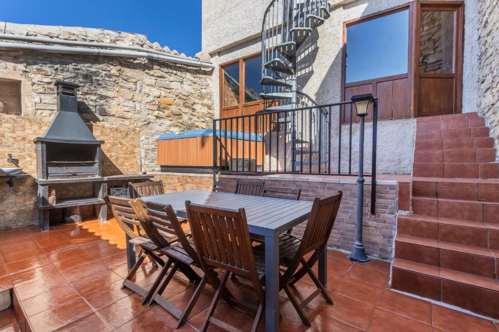 a patio with a table and chairs and a fireplace at Ca La Pascola in Guimerá