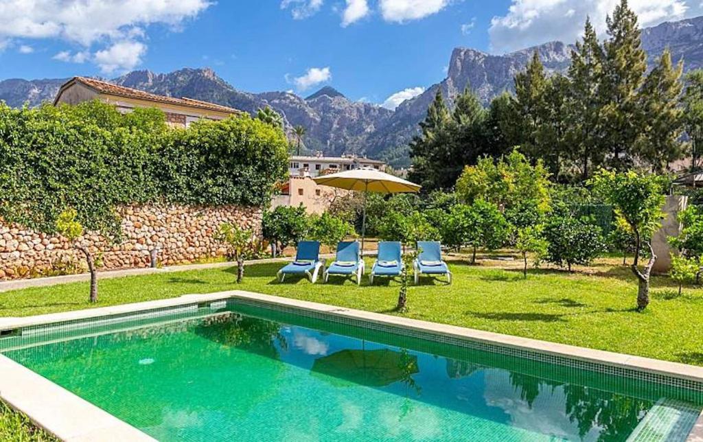 a swimming pool with two chairs and an umbrella at Casa Futbol in Sóller