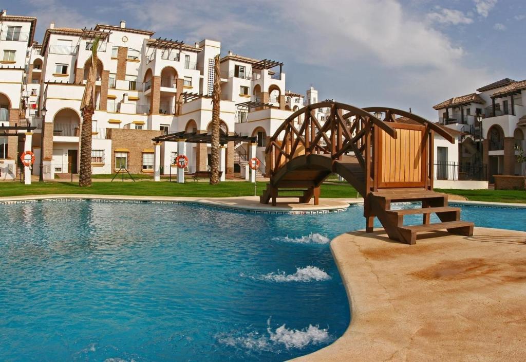 a wooden bench sitting in the middle of a swimming pool at 2 bed apartment with pools and spa in Vera