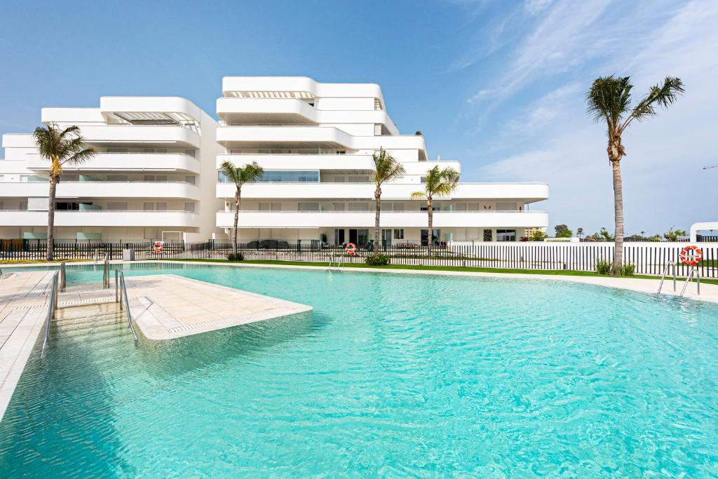 a swimming pool in front of a building at Horus Beach Paradise in Torre del Mar