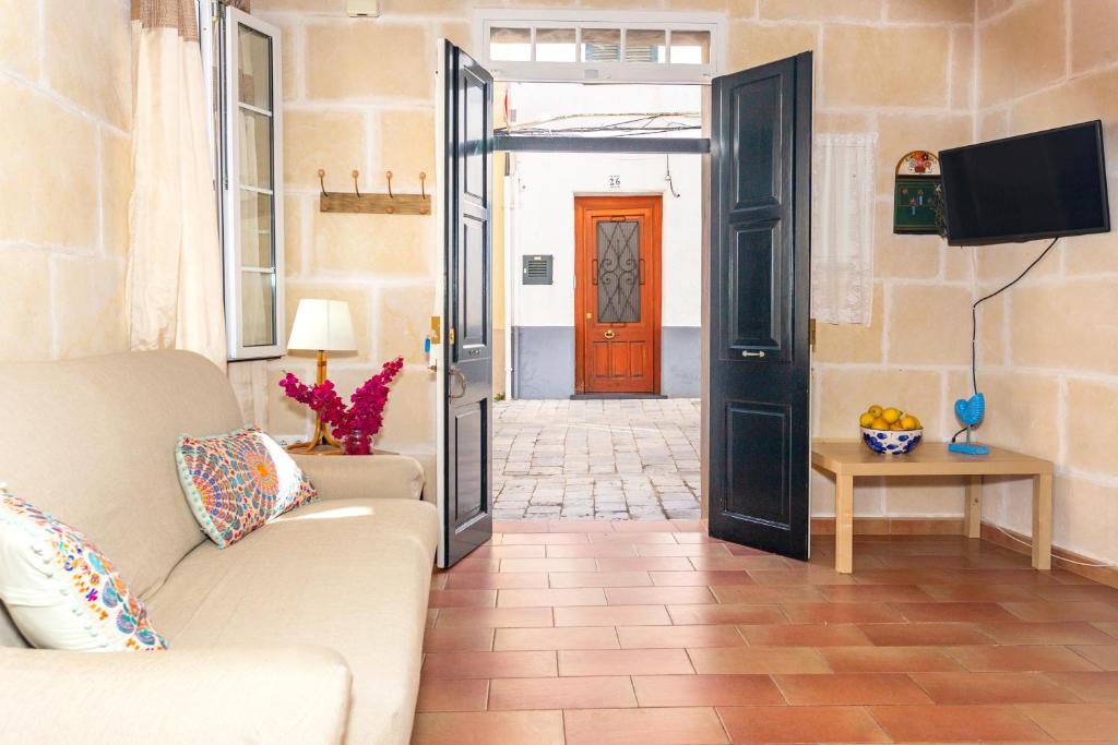 a living room with a couch and a door at Casa de Ses Roques in Ciutadella