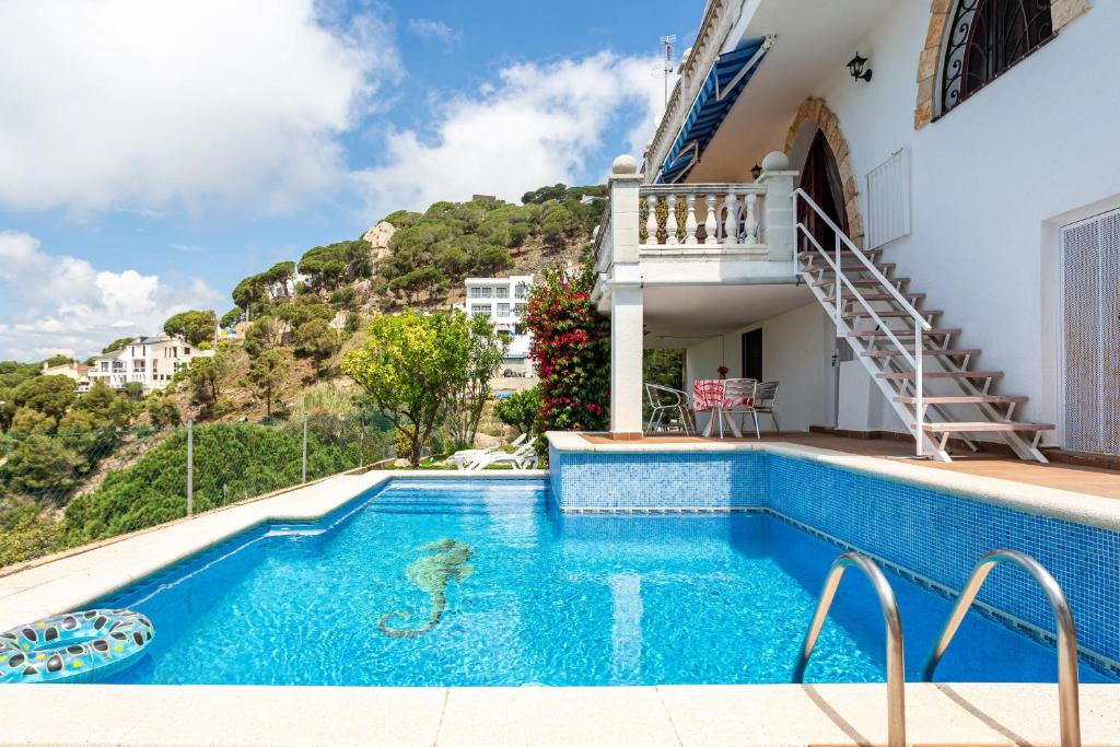 a villa with a swimming pool and a mountain at Tresa in Lloret de Mar