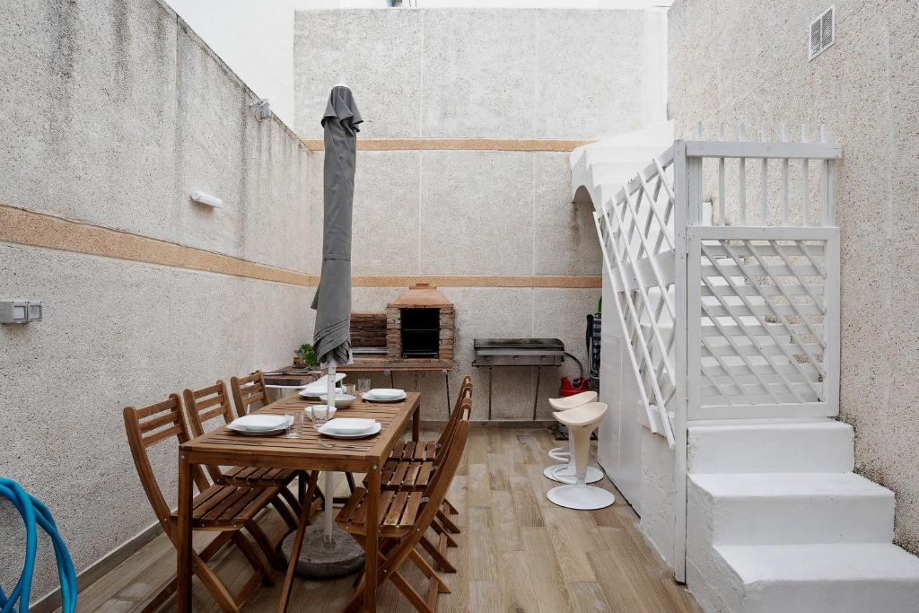 a dining room with a table and chairs and stairs at Piso Pablo in Barbate