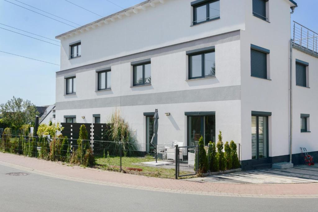 a white building on the side of a street at Luxusvilla Neubau 1 in Oberasbach