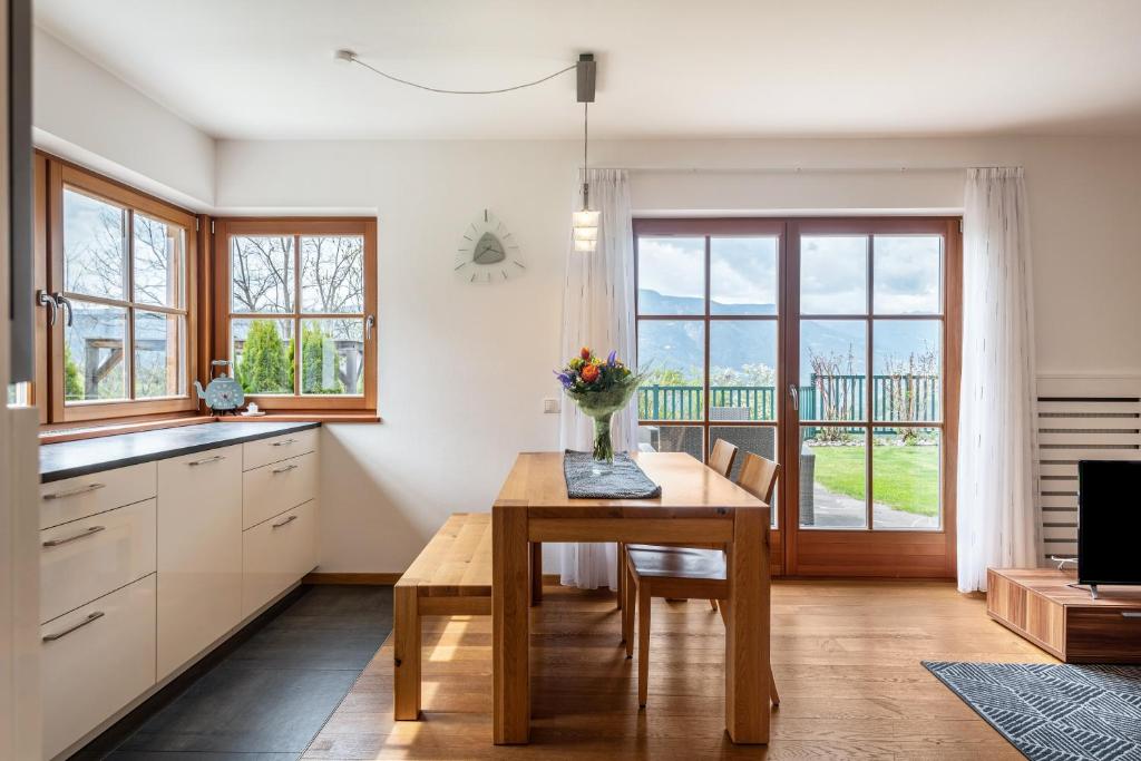 a kitchen with a table with a vase of flowers on it at Apartement Santner in Siusi