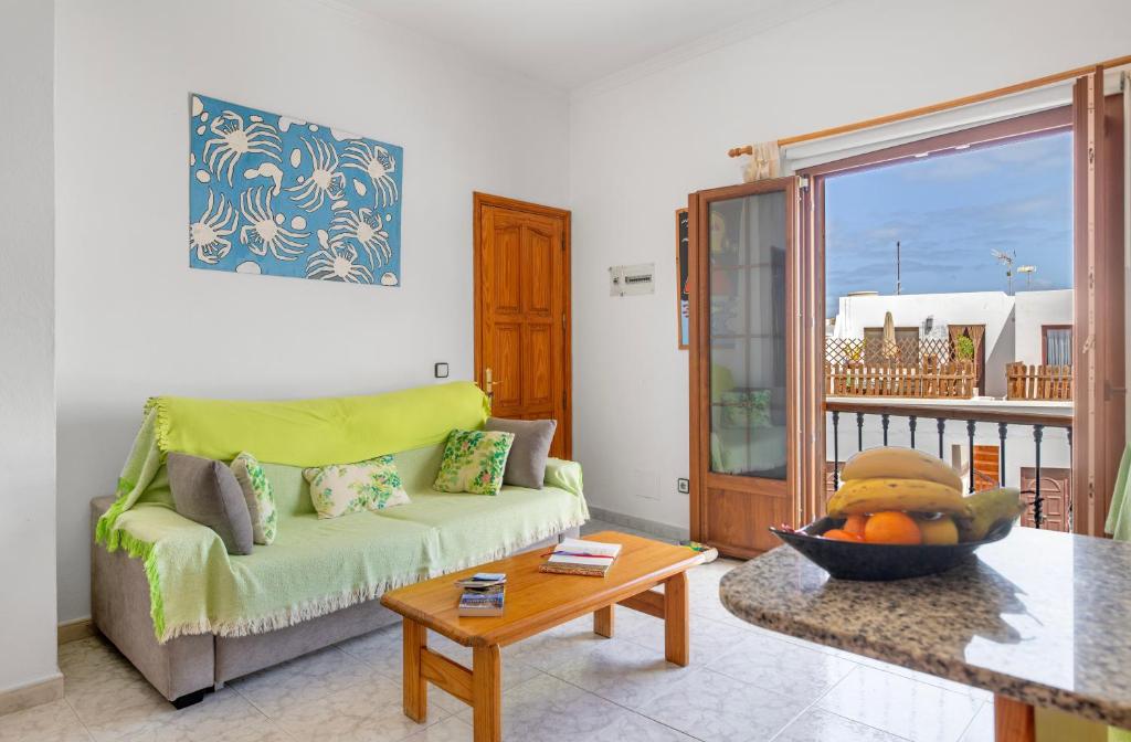 a living room with a couch and a table at Casita Isabella in El Golfo