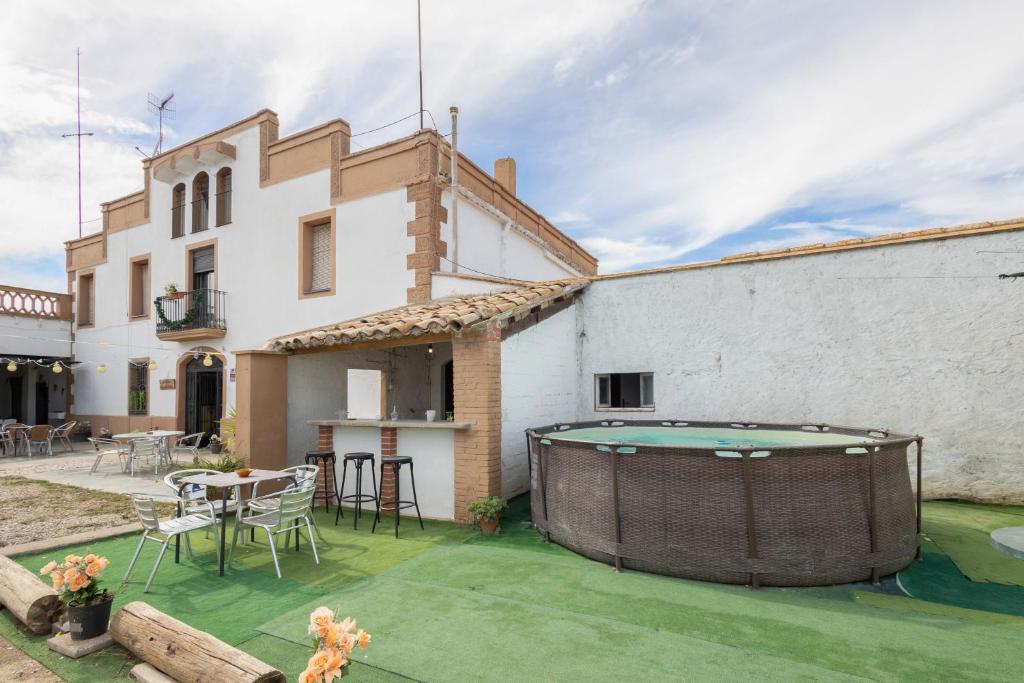 a backyard with a pool and a table and a building at Masia Cal Vies in Castellví de la Marca