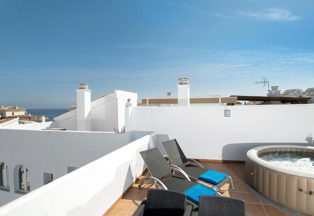 a balcony with chairs and a hot tub on a building at Casa Chana in Almuñécar