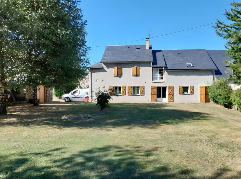 a large white house with a car parked in the yard at Séjour Nature à Campan in Campan