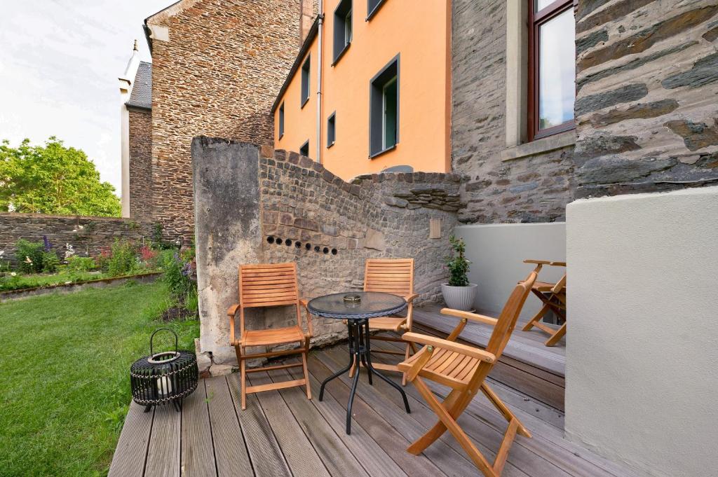 a patio with chairs and a table on a deck at Alte Stadtvilla Weinberg 5 in Traben-Trarbach