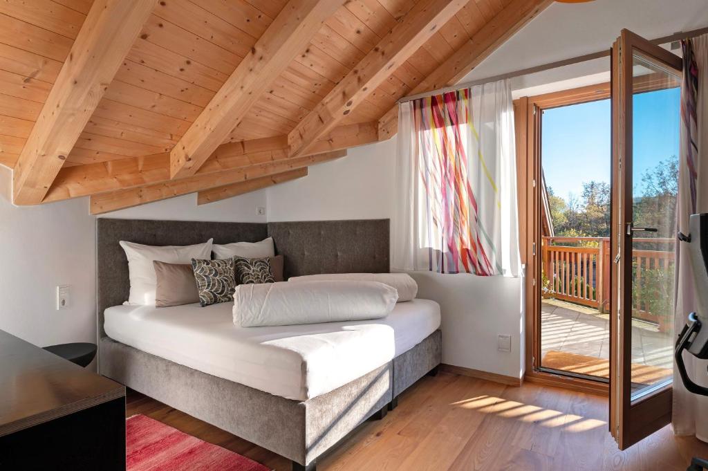 a bedroom with a bed and a large window at Residence Skutial Santner Deluxe in Castelrotto
