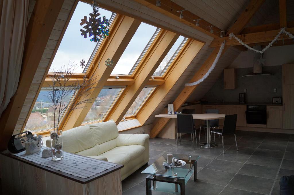 a living room with a couch and some windows at Gîtes du Taennchel in Thannenkirch