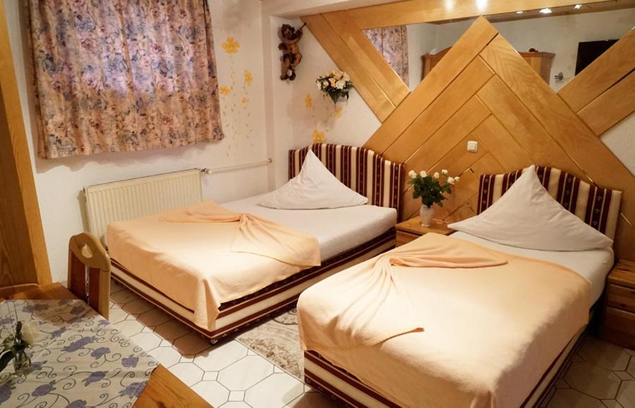 um quarto com duas camas num quarto em Top Hotel Edingen em Edingen-Neckarhausen