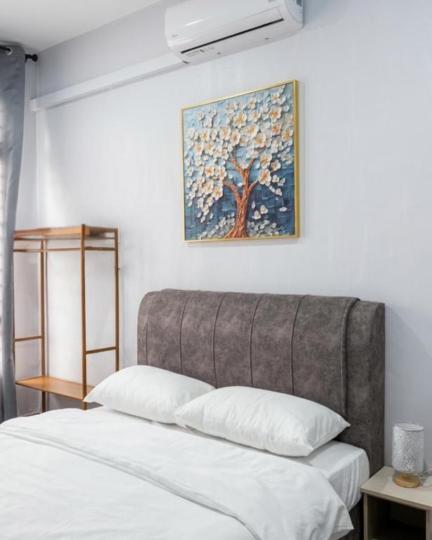 a bedroom with two beds and a painting on the wall at Kanvas 21 in Jerantut