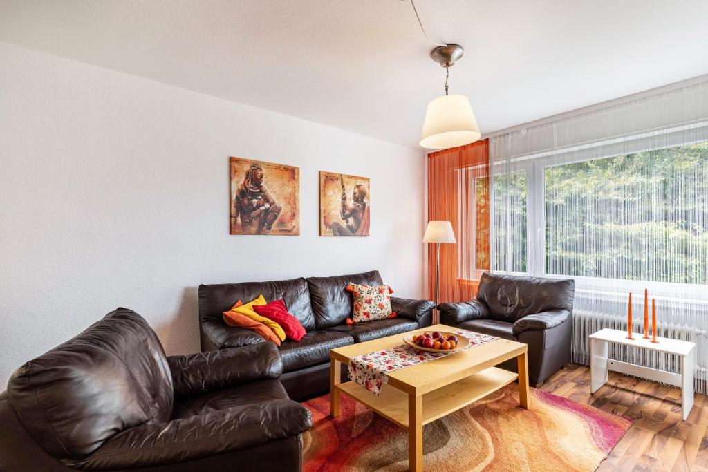a living room with a leather couch and a table at Ferienwohnung Am Paradies in Baden-Baden