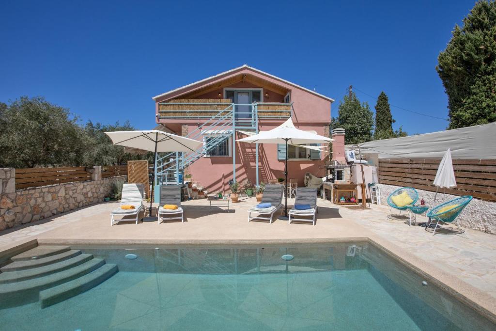 a house with a swimming pool with chairs and umbrellas at Zante Villa Amici Loft in Zakynthos