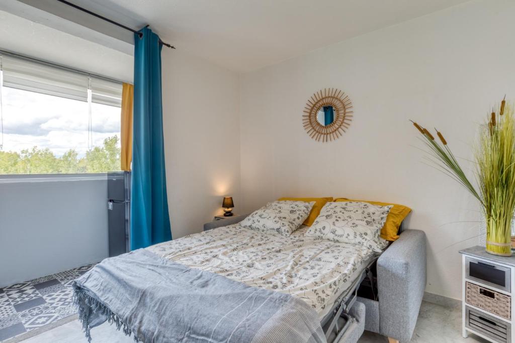 a bedroom with a bed and a window at Le Cosy à la grande pyramide in La Grande Motte