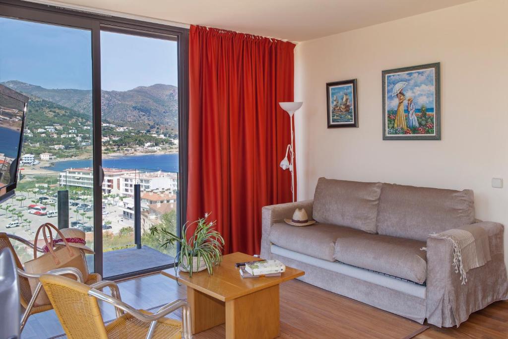 a living room with a couch and a large window at Apartamento Torre Gran Luxe in Port de la Selva
