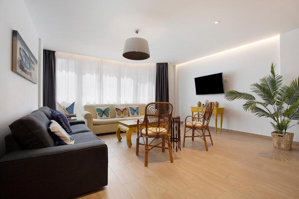 a living room with a couch and a table and chairs at Falco 1 in Corralejo