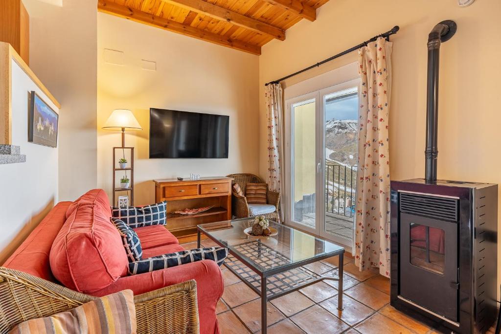 a living room with a fireplace and a tv at Le Chalet Sierra Nevada in Monachil