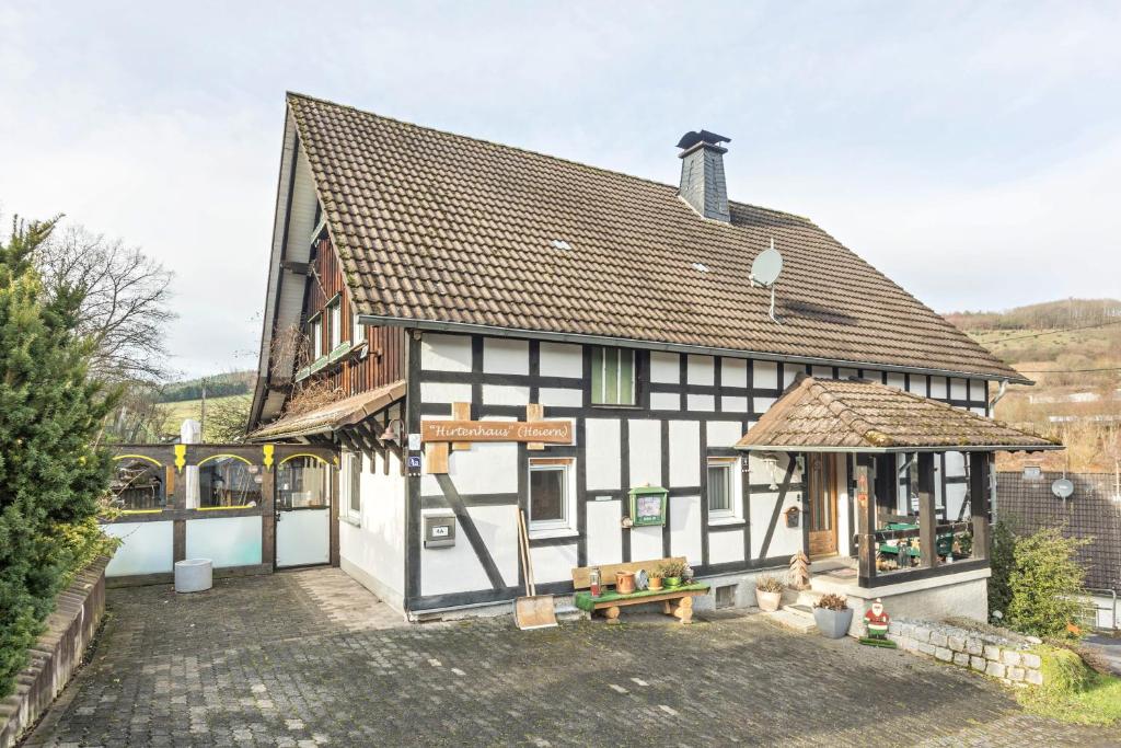 a white and black building with a gazebo at Feriewohnung Hirtenhaus in Attendorn