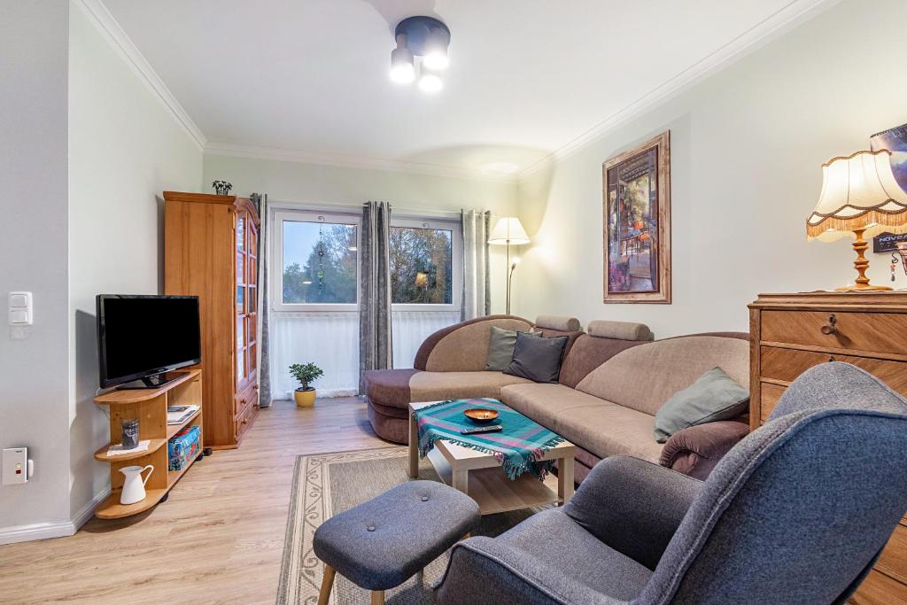 a living room with a couch and a tv at Apartment On The Upper Floor in Bokelrehm