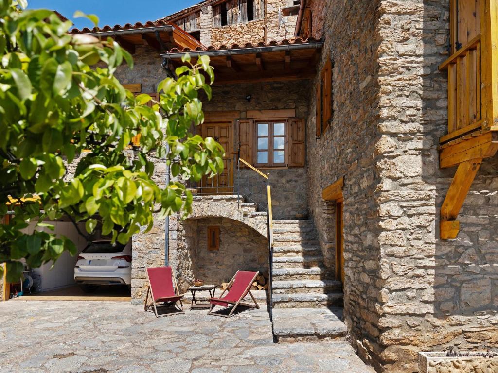 two chairs and a table in front of a building at Chalet de montaña con vistas in Prullans