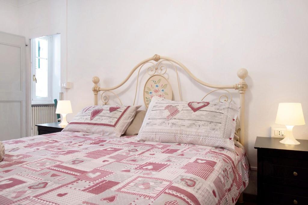 a bedroom with a pink bed with two pillows at La Vecchia Torre in Porto Valtravaglia