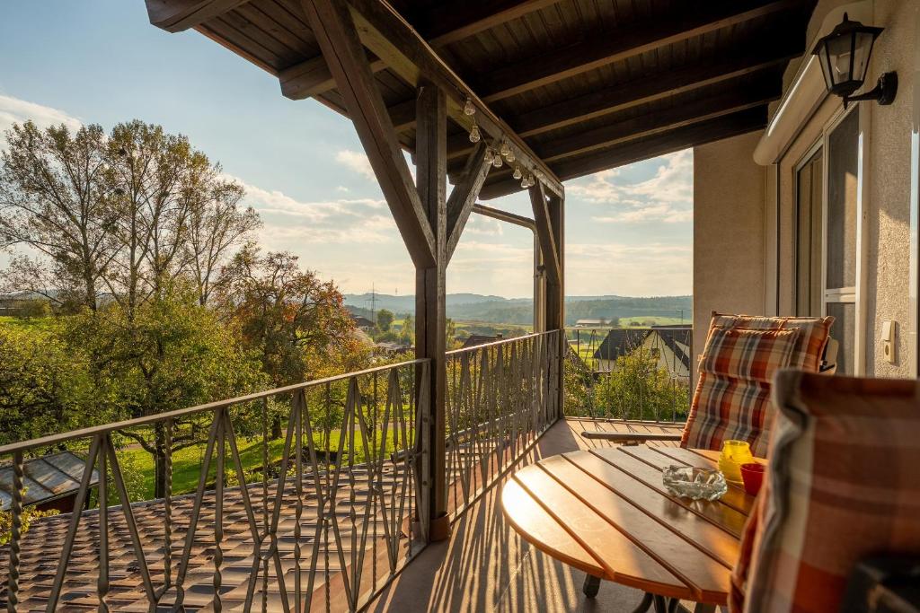 a balcony with a wooden table and a chair at Ferienwohnung Agnes in Rheinfelden