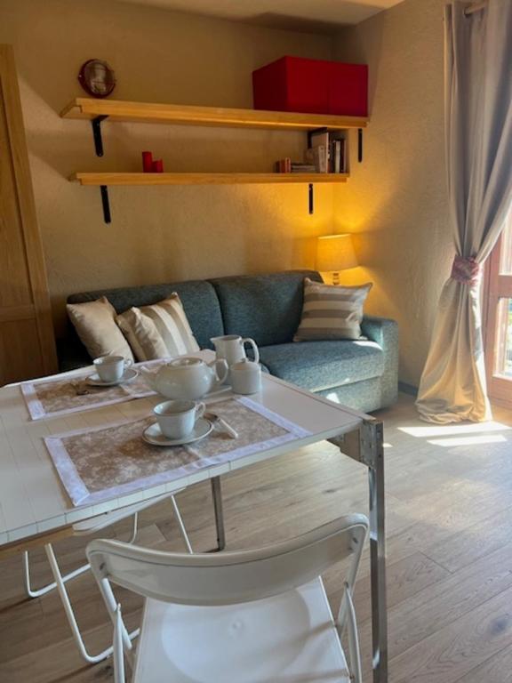 a living room with a table and a couch at Ninette, intimità e natura in Sauze di Cesana