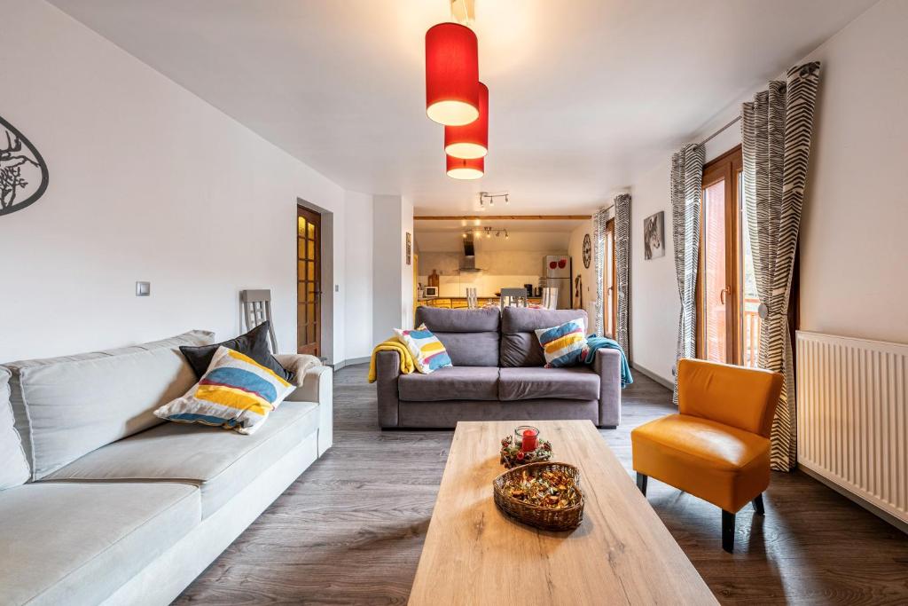a living room with a couch and a table at Chalet les églantiers in Valloire