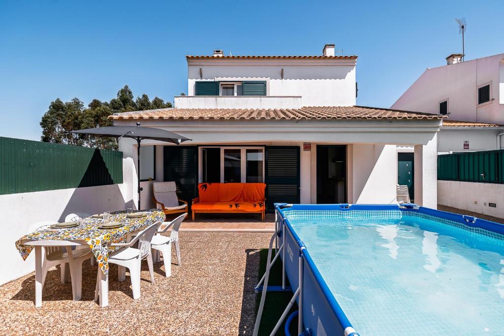 a patio with a table and a swimming pool at Casa d' Ana in Sesimbra