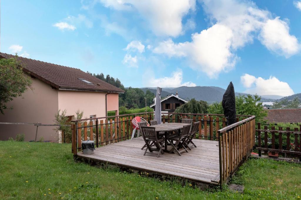 a wooden deck with a table and chairs on it at Gite La Sabaudia in Gérardmer