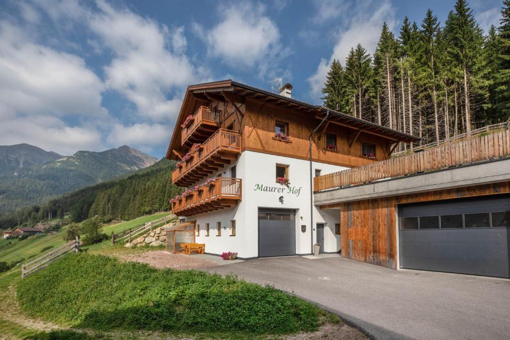a building with a garage on the side of it at Pfattenspitz Maurerhof in Valdurna