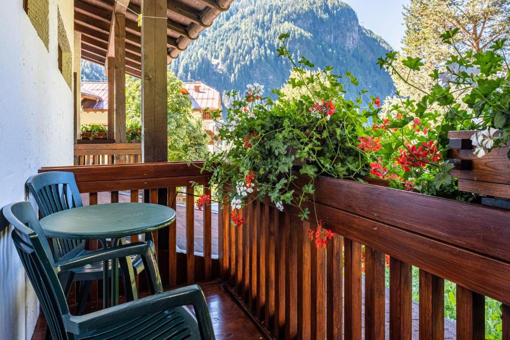 a balcony with a table and chairs and flowers at Cesa Soramurat Appartamento 4 in Canazei