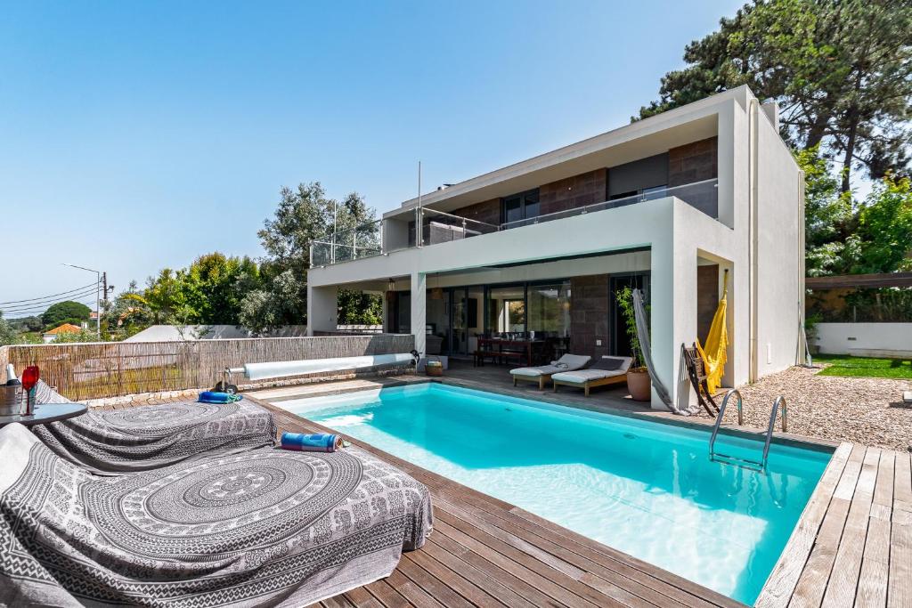 a home with a swimming pool and a house at Casa Praia do Meco in Sesimbra
