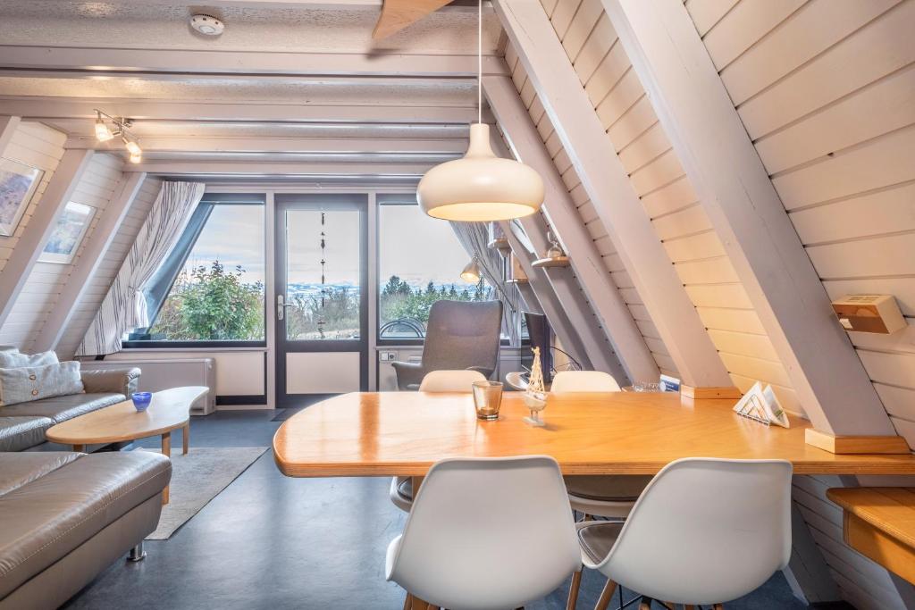 a living room with a wooden table and white chairs at Seeblick in Immenstaad am Bodensee