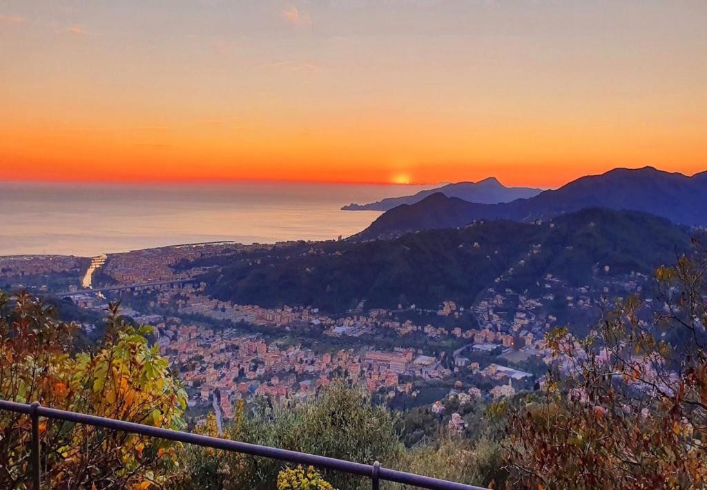 a view of a city at sunset from a mountain at Paradiso San Giacomo in Cogorno