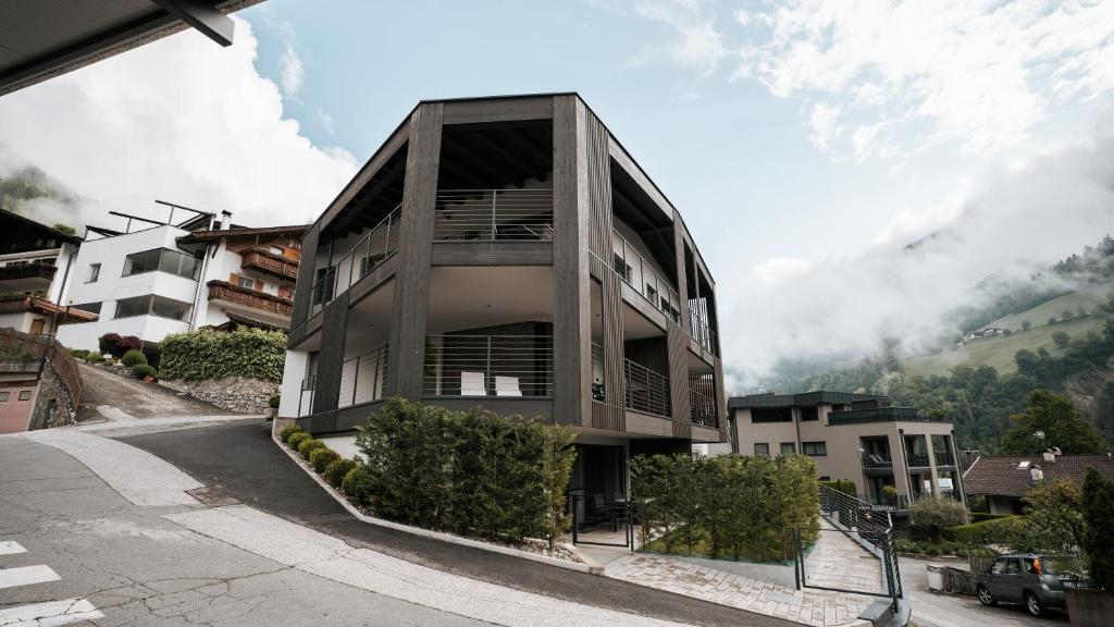 a building on a street with a mountain at Aktiv Lodge Meran - Terrace Two in San Martino